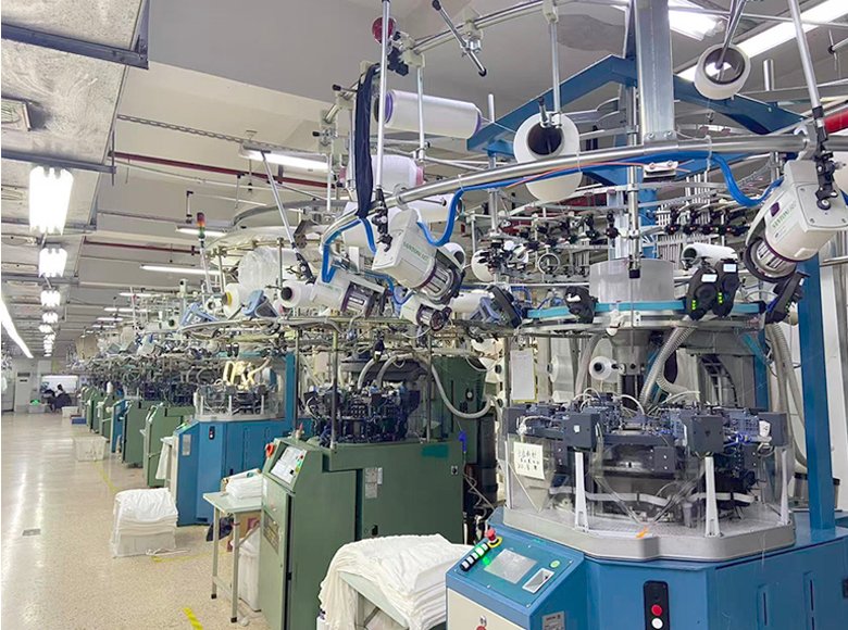 A line of SANTONI circular knitting machines in a workshop